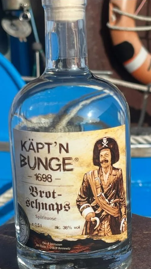 Flasche Käpt'n Bunge Brotschnaps vor Rettungsring und Tauwerk
