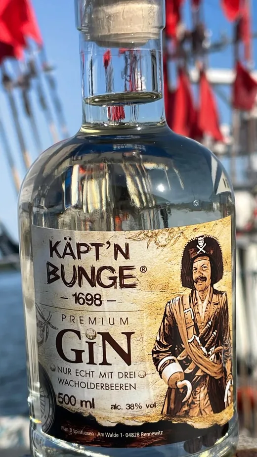 Flasche Käpt'n Bunge Premium Gin vor roten Fähnchen