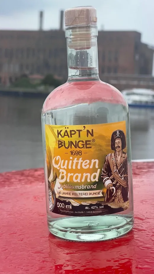 Flasche Käpt'n Bunge Quitten Brand auf einem roten Poller am Hafen